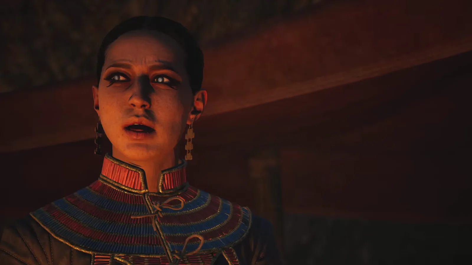 Close-up of Lacra, the vampire companion, in her embroidered red-and-blue collar robe inside a Svartra hideout in The Blood of Dawnwalker
